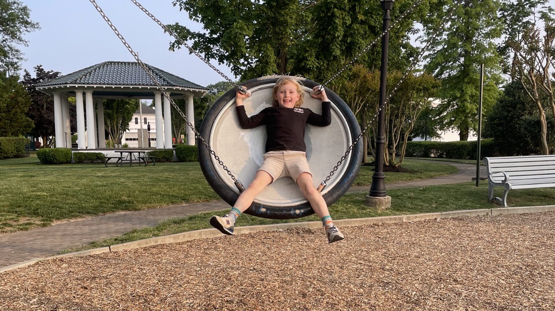 A young boy swings with a big grin on his face.